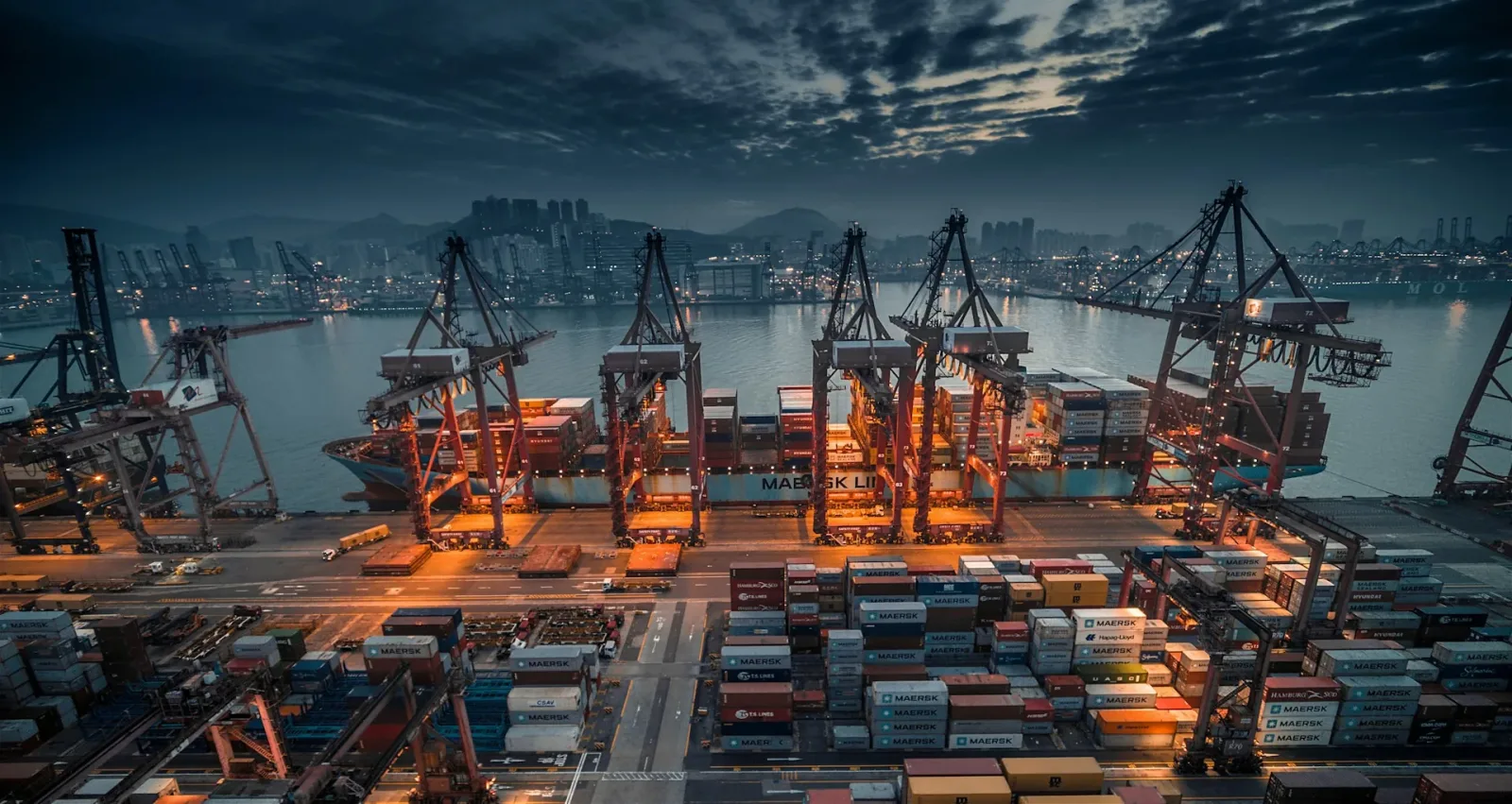 Containerbrücken im nächtlichen Hafen beim Umschlag